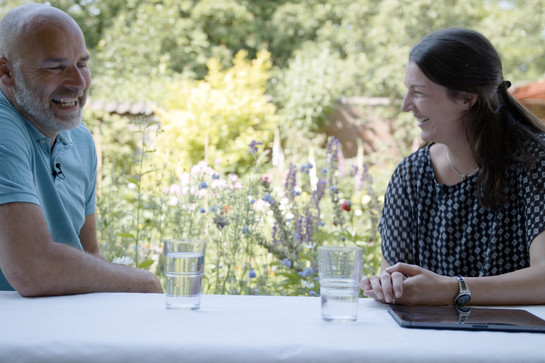York lacht mit einer brünetten Frau im Garten