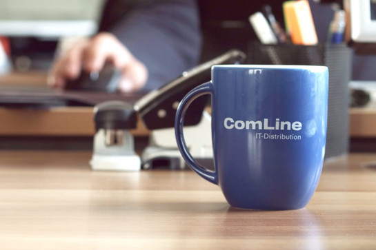 bb_comline_teaser_05.jpg Eine blaue Comline Tasse steht auf einem Holztisch