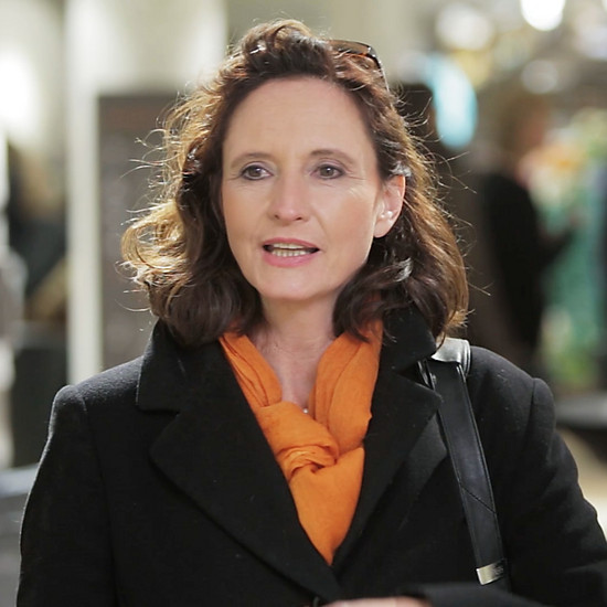 Eine brünette Frau trägt einen orangenen Schal