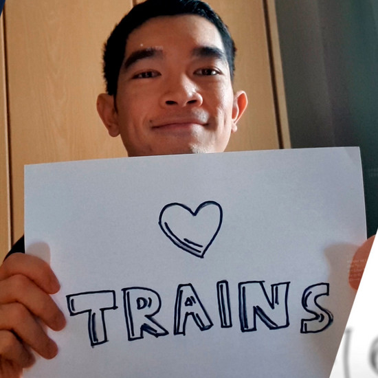 Abschiedsfilm für Mobilitätsbranche Ein Mann hält ein Schild mit "I love trains" in der Hand.