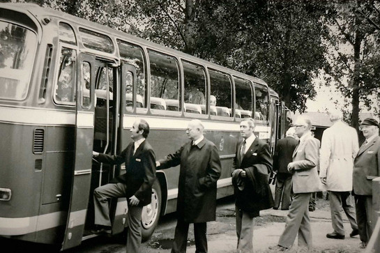 Historische Aufnahme von Geschäftsmännern, die in einen Bus einsteigen