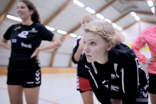 Eine Handballspielerin dehnt sich