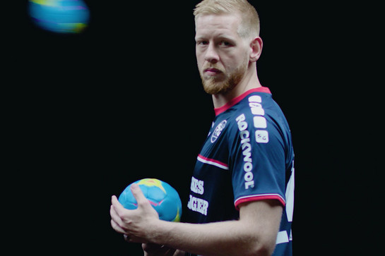 Ein blonder SG Spieler hält einen Ball