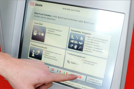 Lars tippt auf einen Ticketautomaten