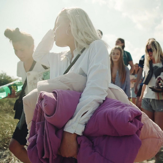 Ein blondes Mädchen trägt zwei Decken