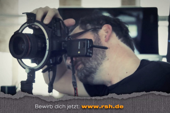Ein Mann guckt durch eine Kamera