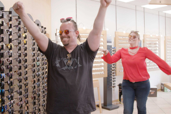 Ein Mann und eine Frau jubeln beim Optiker