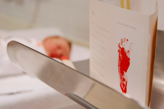 Roter Fußabdruck eines Säuglings auf einem weißen Papier