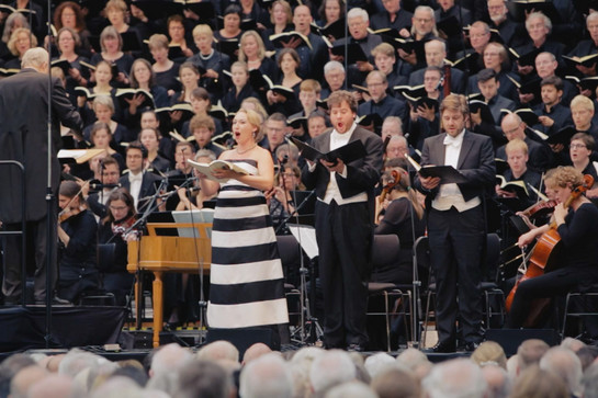 Eine Opernsängerin steht auf der Bühne und singt