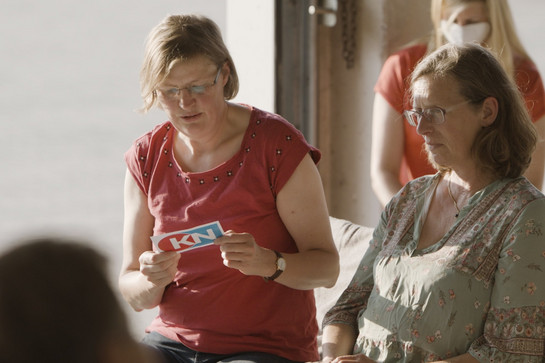 Eine Frau liest etwas von einer Karte auf
