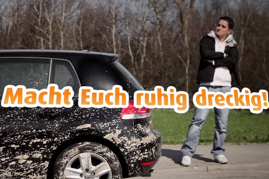 Eine Frau steht vor einem dreckigen Golf