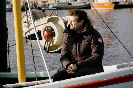 Mads Schreiner sitzt auf einem Boot