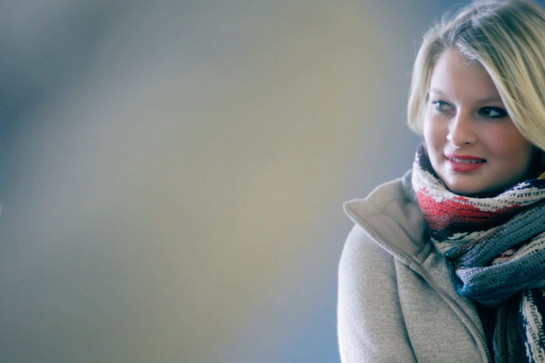 Eine blonde Frau mit einem gestrickten Schal