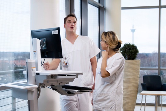 Zwei Krankenpfleger stehen vor einem Gerät