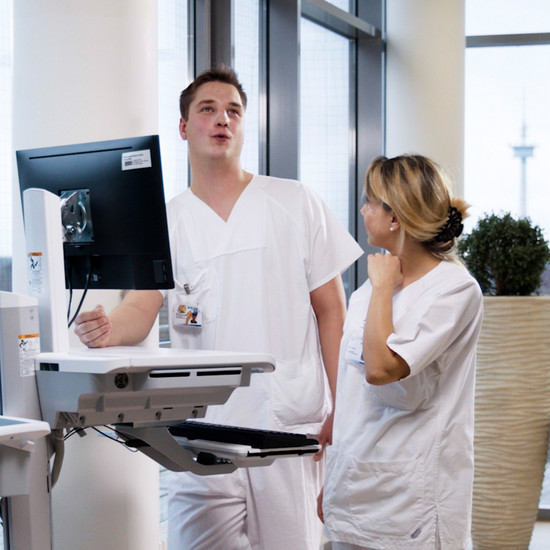 Zwei Krankenpfleger stehen vor einem Gerät