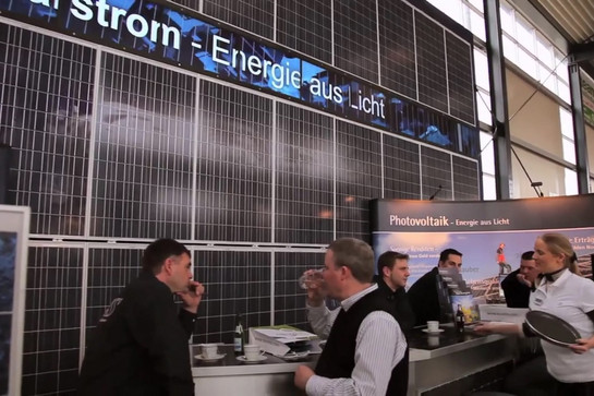 Personen stehen an einem Messestand von EWS