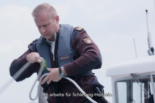 Ein Polizei Beamte wickelt ein Tau zusammen