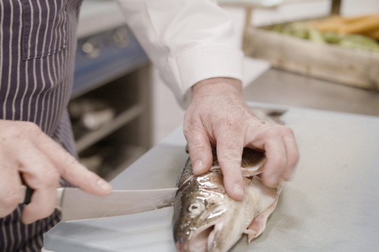 Pierre Binder schneidet einen Fisch auf