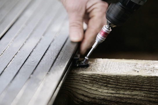 Eine Person bohrt eine Schraube ins Holz