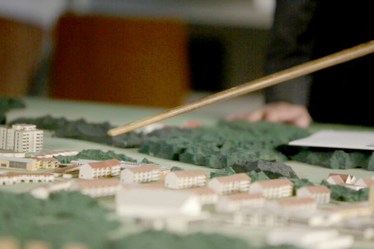 bb_quartier_teaser_02.jpg Ein Stock zeigt auf ein Miniatur Wohnviertel