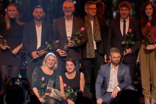Ein Gruppenbild mit Personen die Blumen in den Händen halten