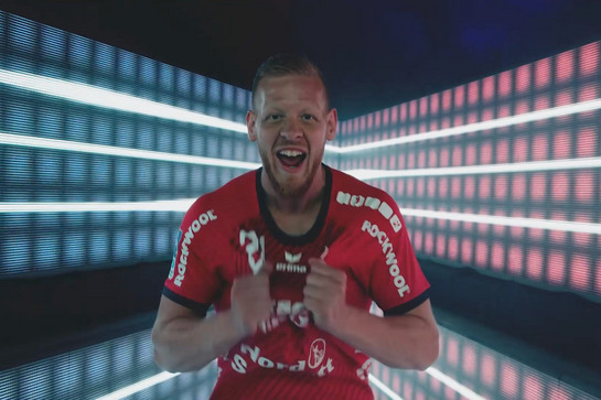 Ein SG Spieler im roten Trikot lächelt in die Kamera