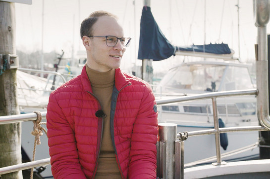 Mann mit roter Jacke auf Kutter