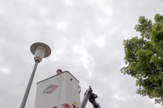 Ein Mann repariert eine Straßenlanterne