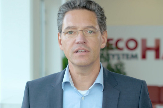 Ein Mann von Eco System Haus guckt in die Kamera