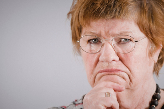 Eine rothaarige Frau guckt grimmig in die Kamera