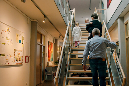 Eltern gehen mit ihren Kindern eine Treppe hoch