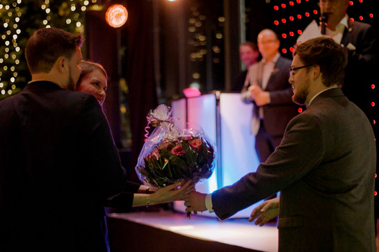 Eine Frau kriegt einen Blumenstrauß überreicht