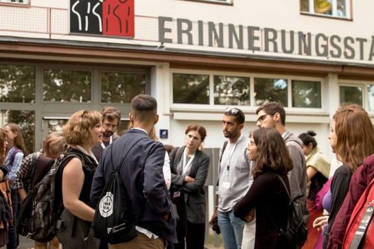 Eine Universitätsklasse steht vor einem Gebäude