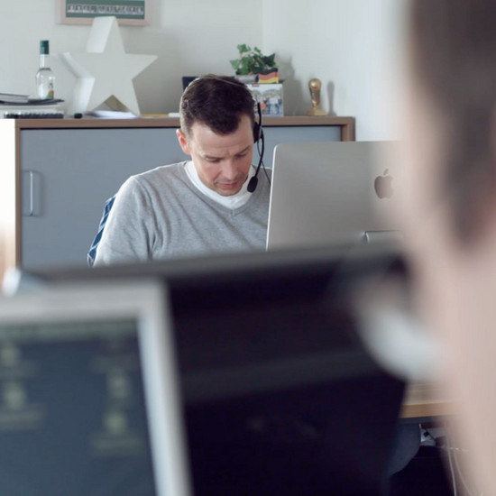 Ein Comline Mitarbeiter trägt ein Headset bei der Arbeit