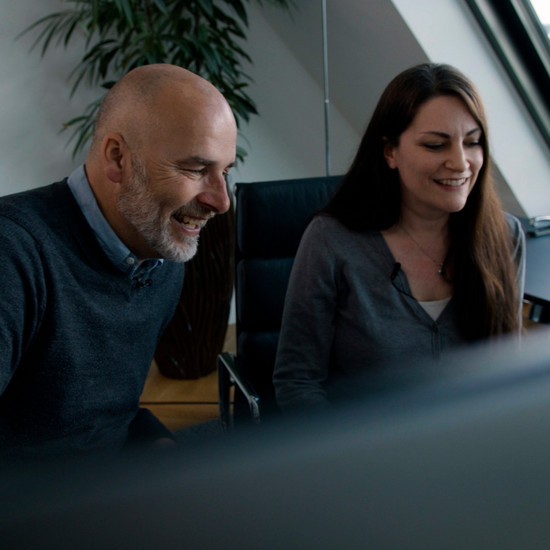 York sitzt mit einer brünetten Frau am Schreibtisch