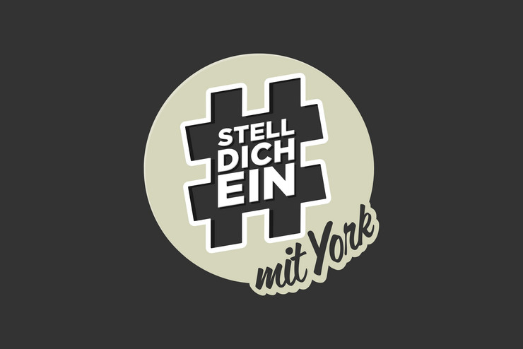 Rundes Logo "Stelldichein mit York" mit grauem Hashtag vor grauem Hintergrund