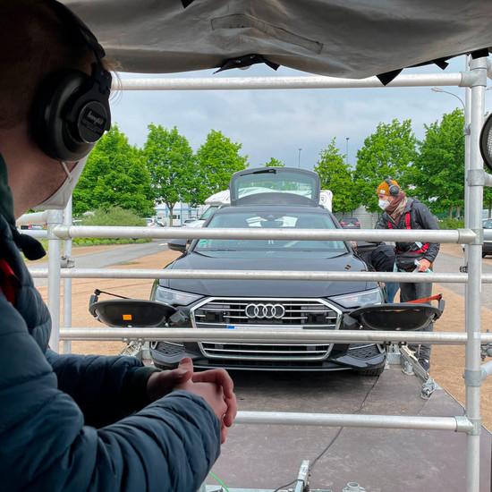 Filmteam auf Parkplatz mit einem Auto