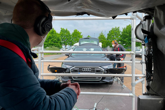 Filmteam auf Parkplatz mit einem Auto