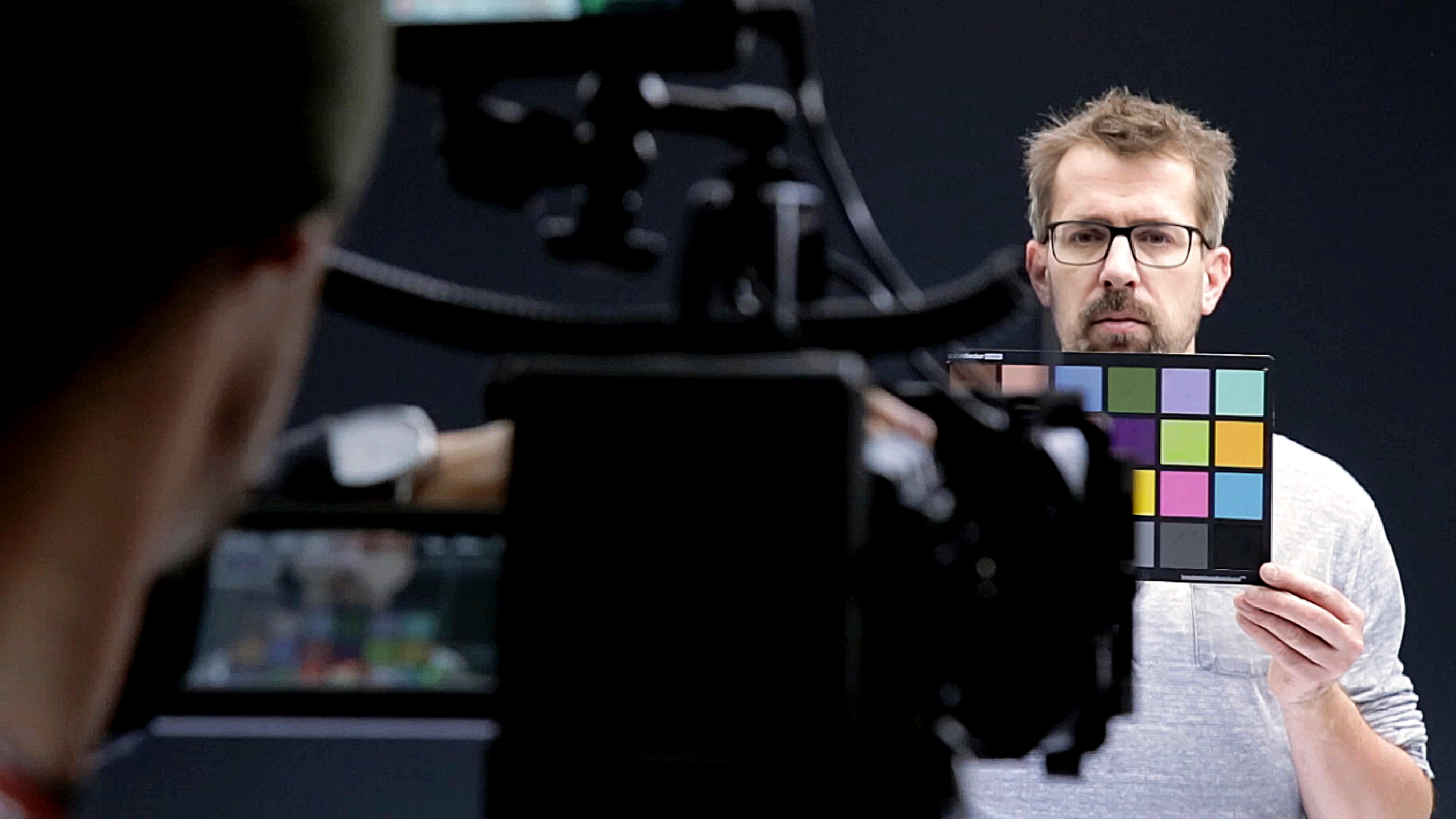 Mann hält Farbpalette vor Kamera