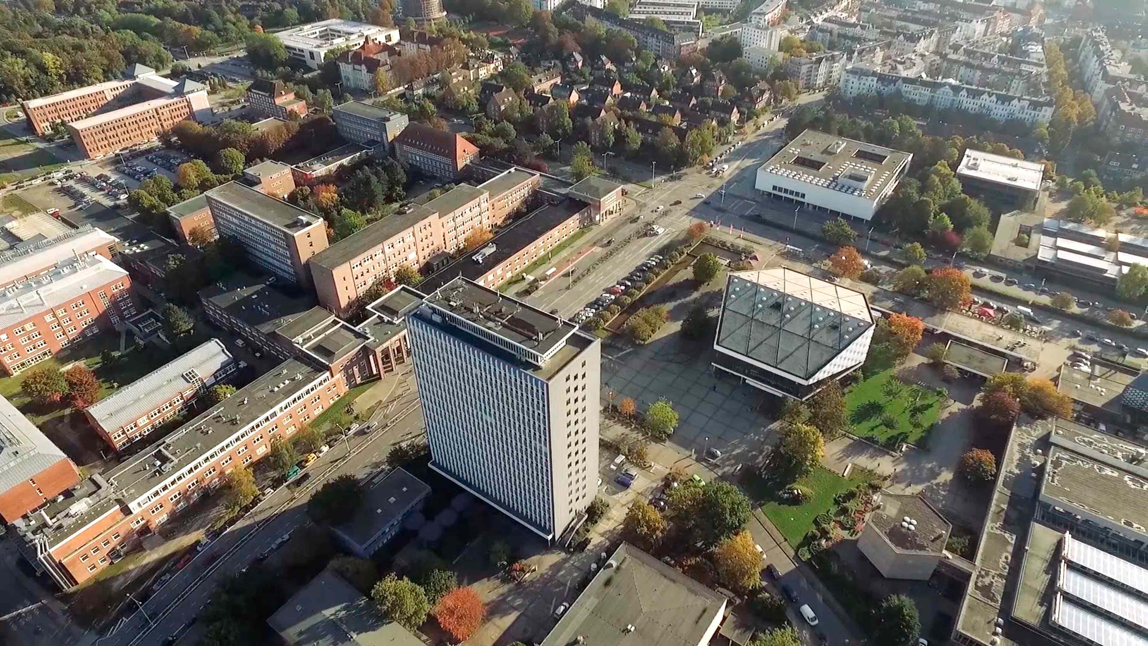 Luftaufnahme einer Stadt: Hochhäuser und Straßen sowie ein Wohnviertel und Autos. 
