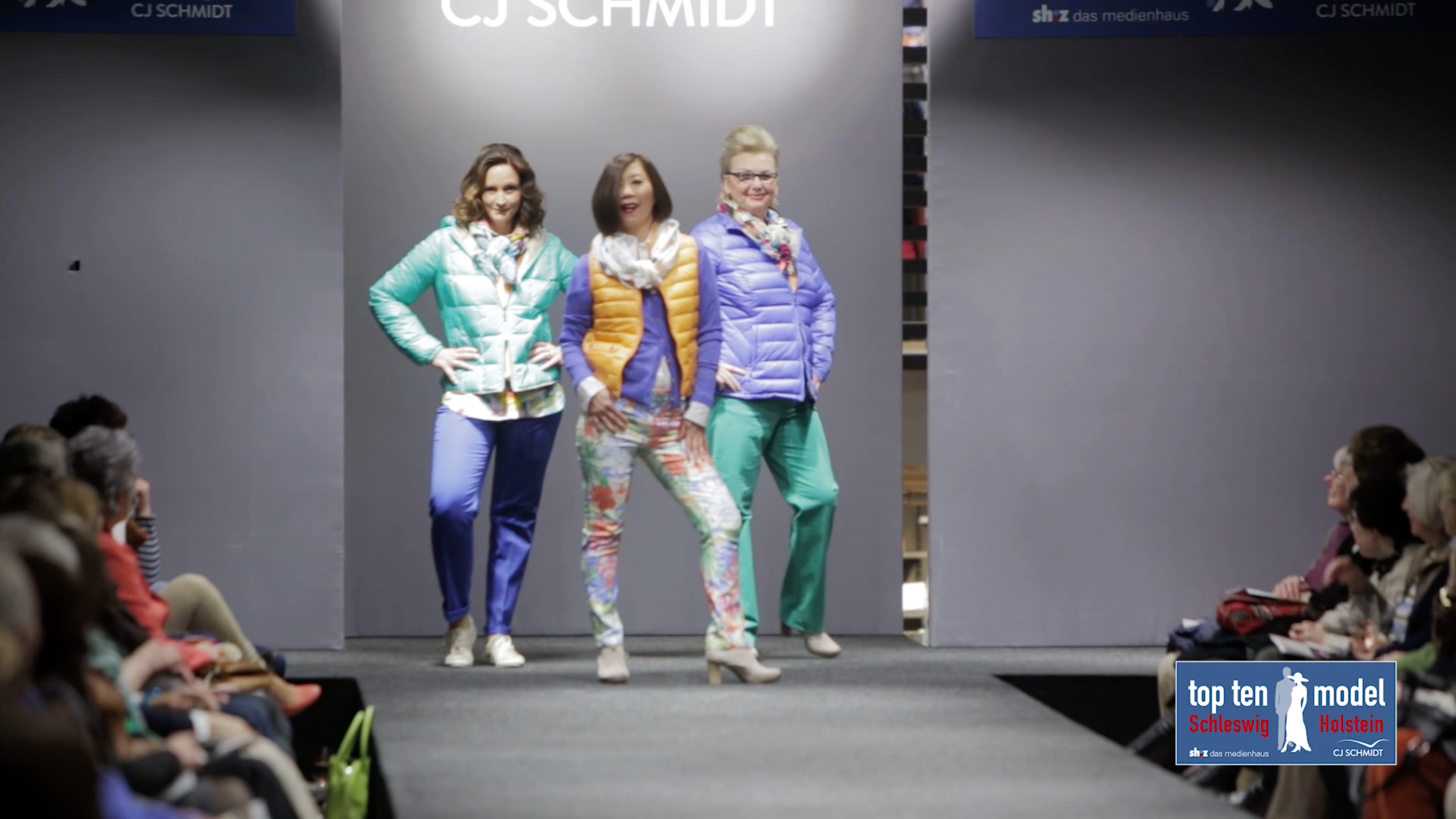 Drei Models posieren in bunten Outfits vor der Kamera