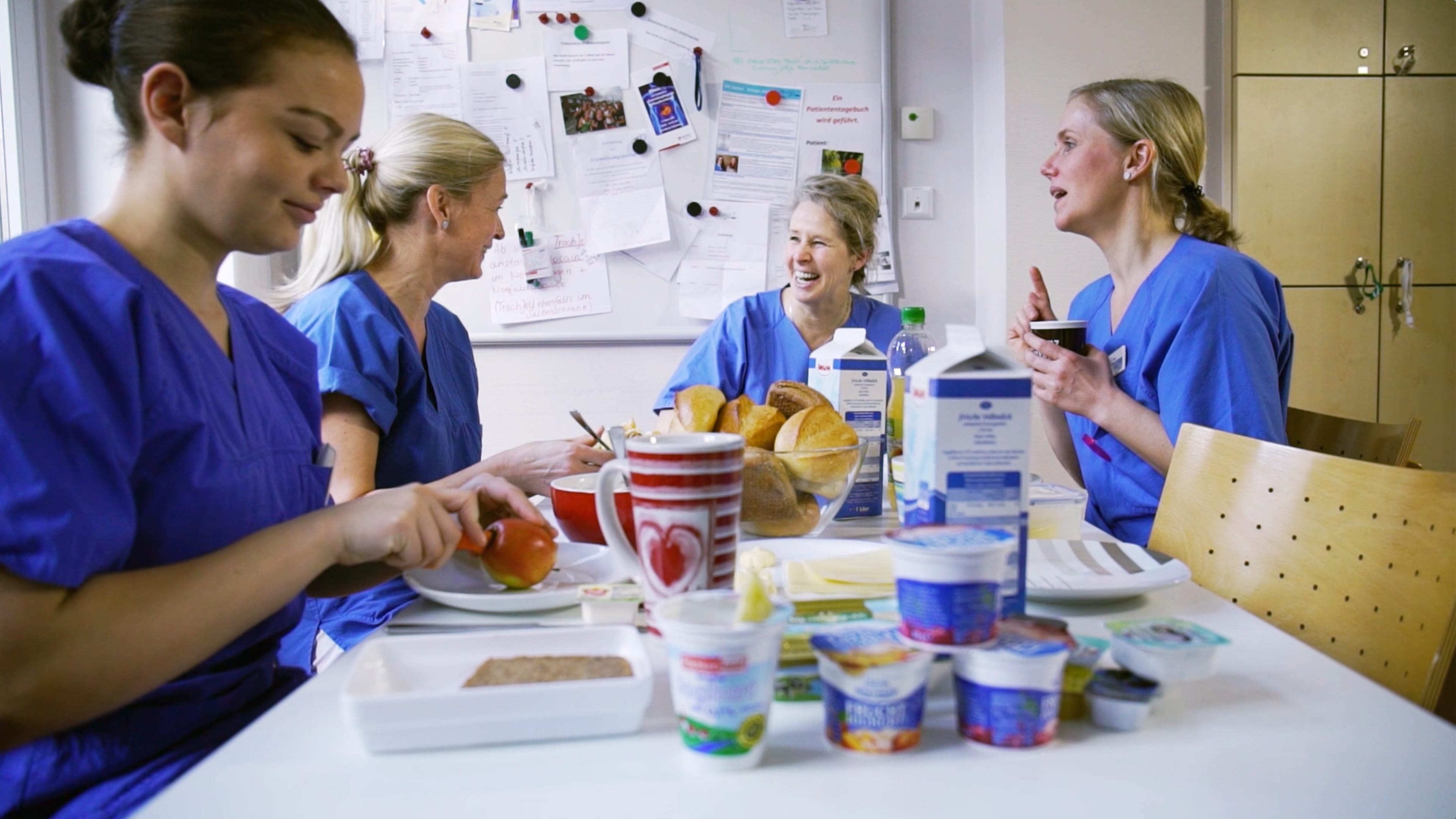 Vier Krankenschwestern sitzen im Schwesternzimmer