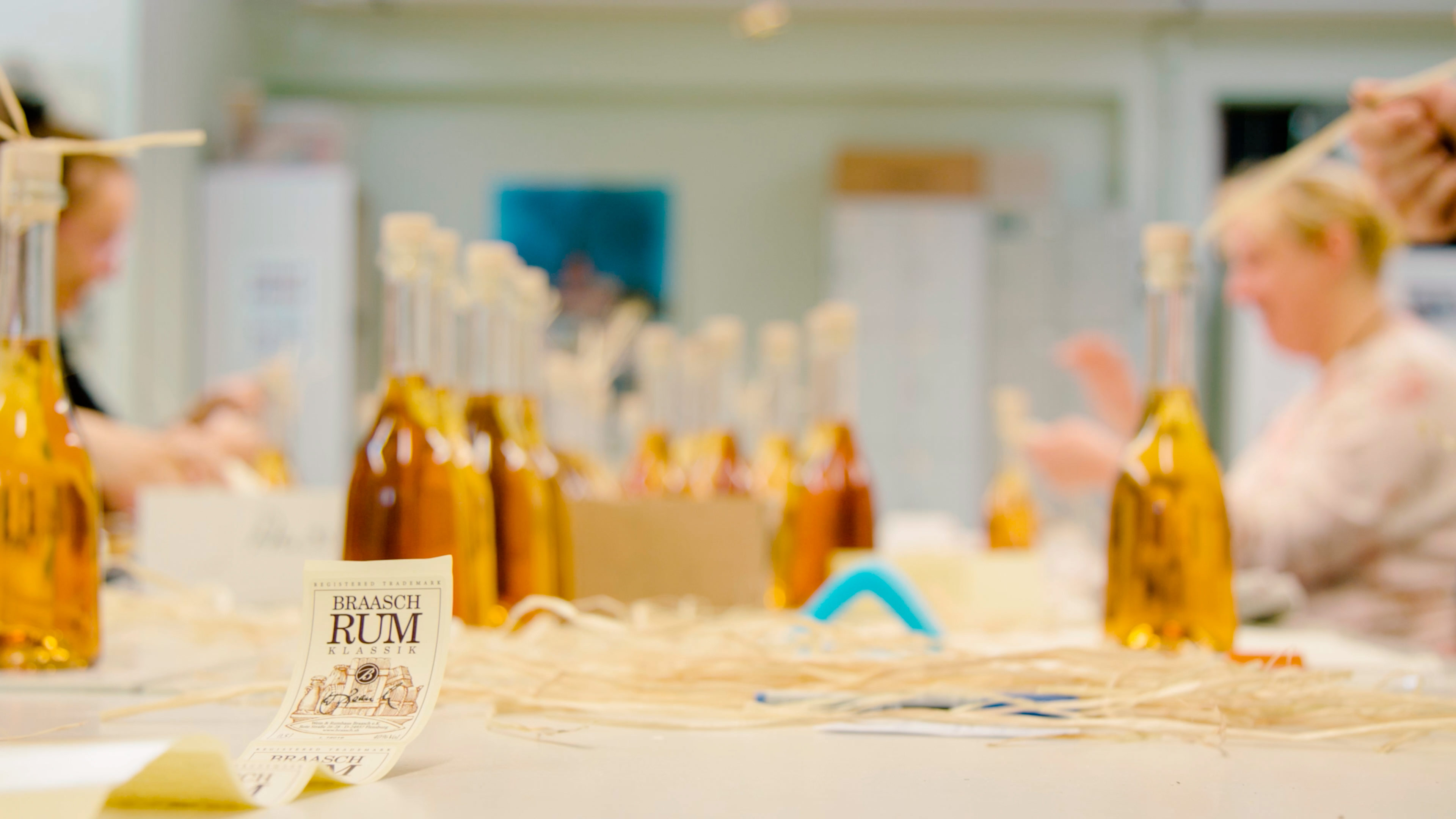 Mitarbeiter der Mürwiker bekleben die Flaschen von Braasch Rum