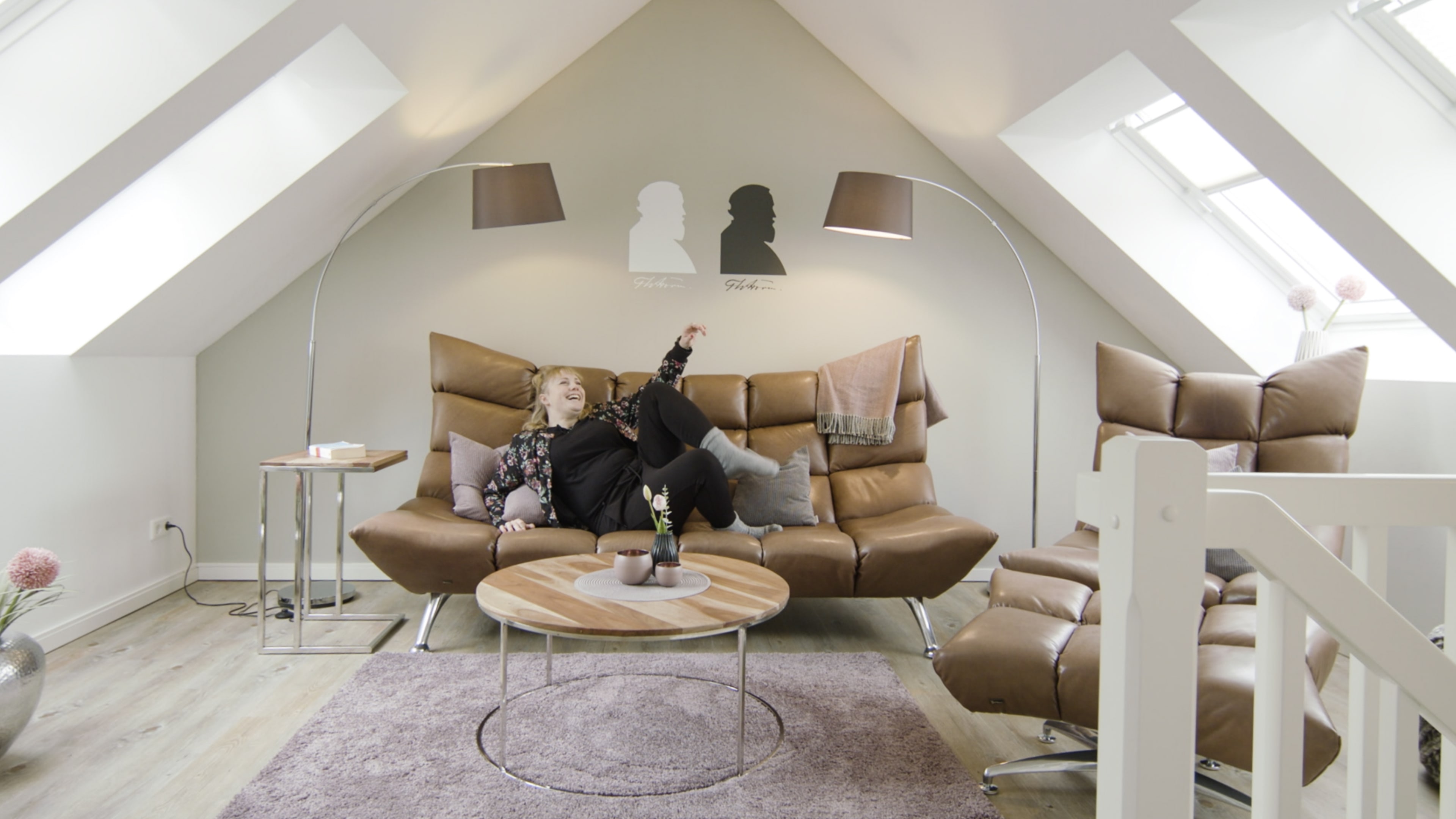 Eine blonde Frau liegt in einem braunen Sofa