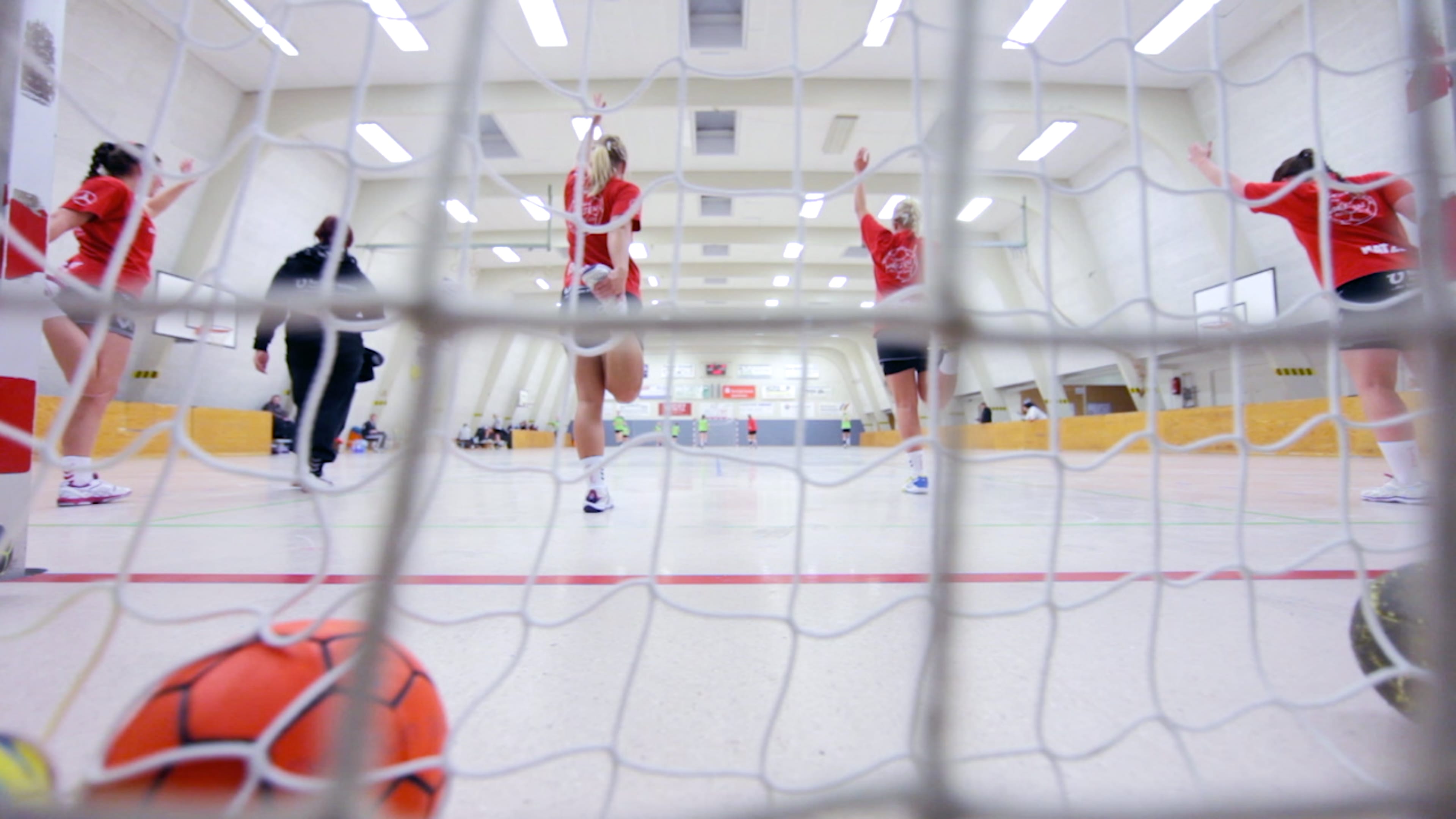Blick durch ein Handballtor auf das Spielfeld