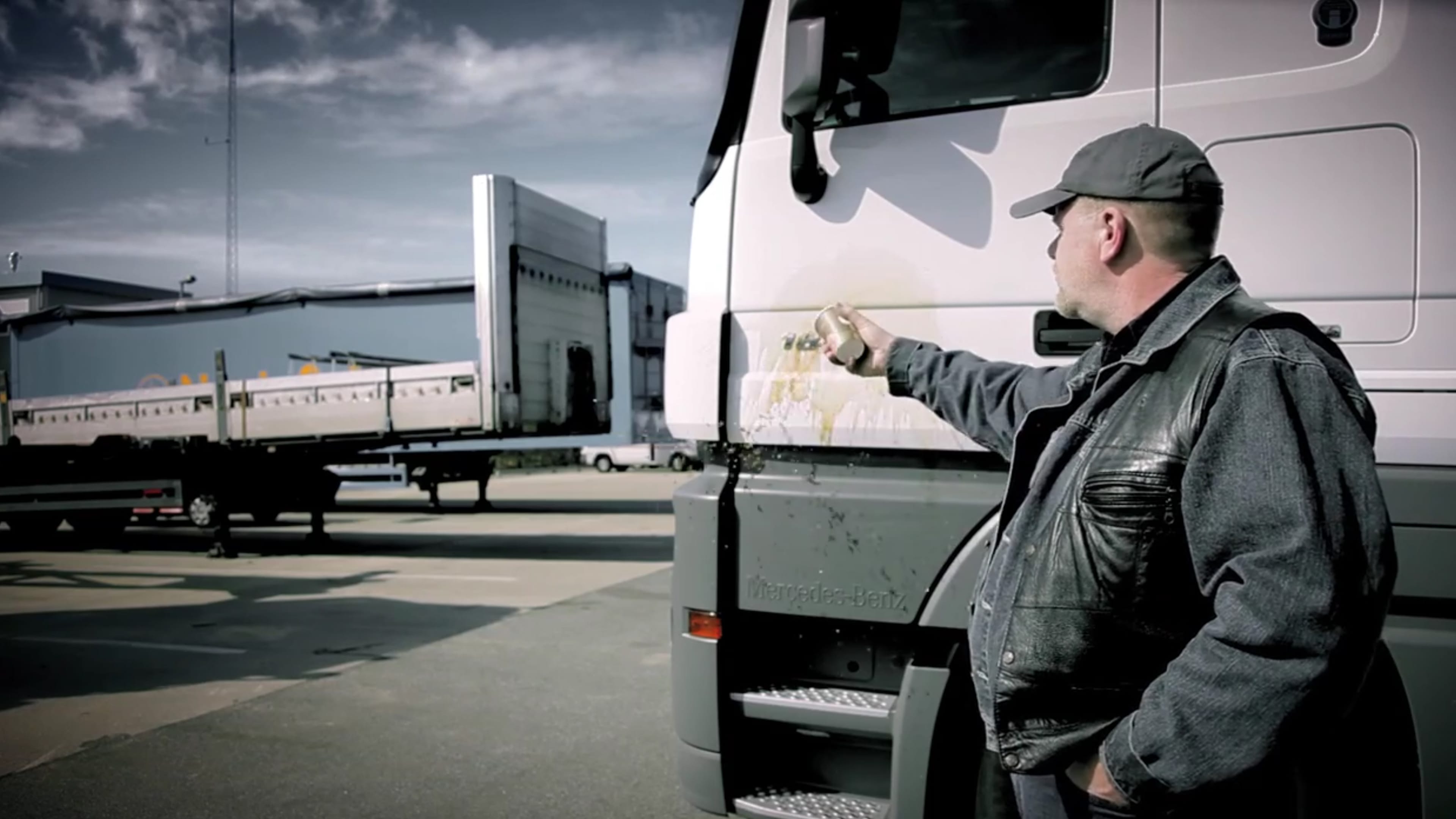 Ein Trucker schüttet Kaffee auf seinen LKW