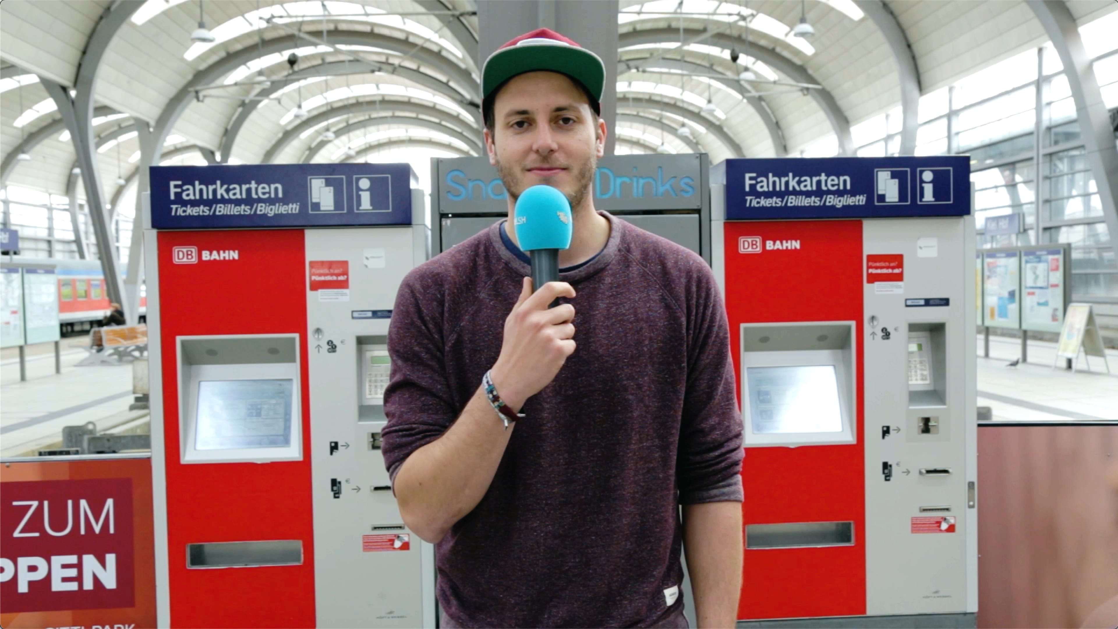 Lars steht vor zwei Ticketautomaten