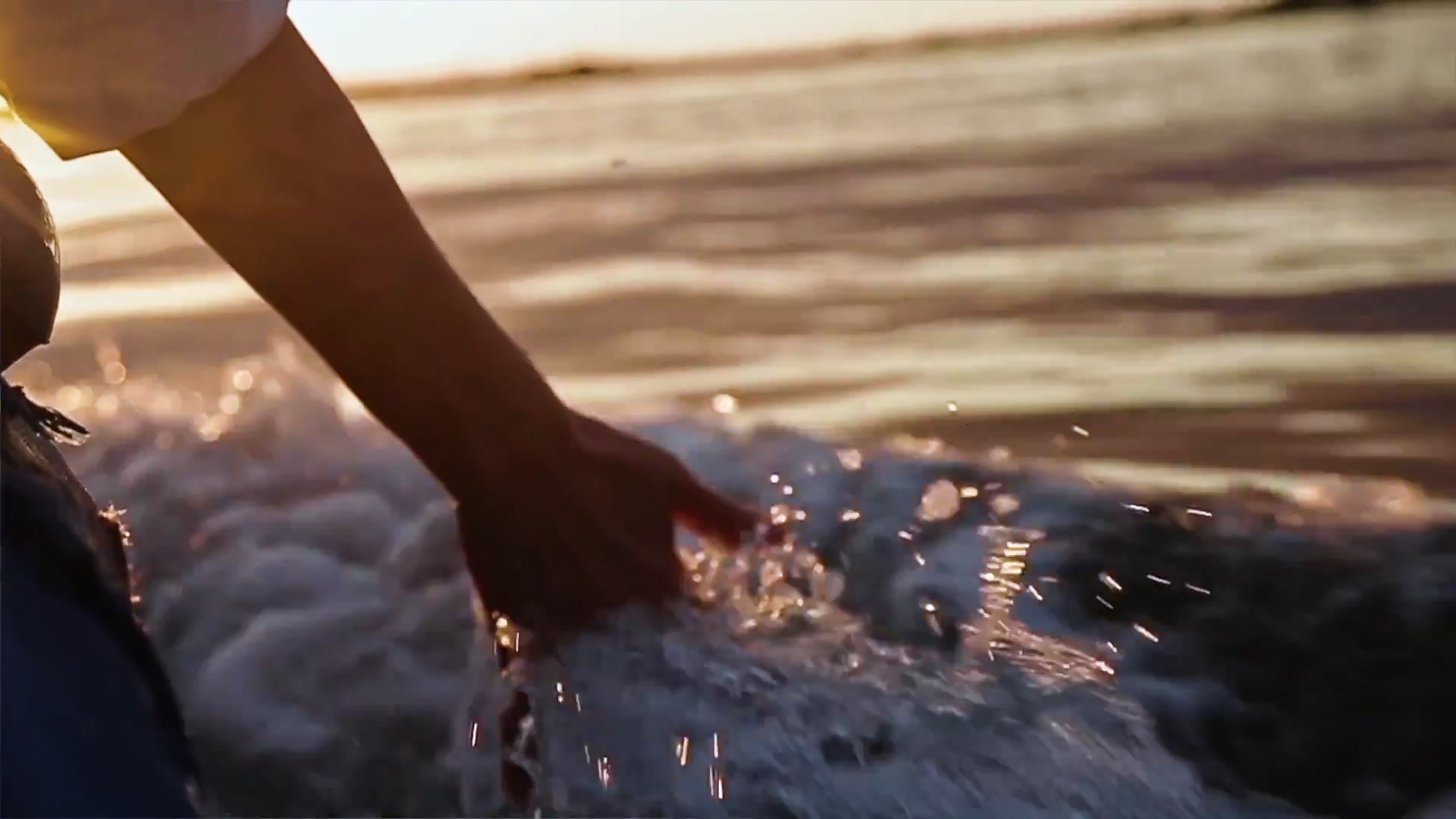 Eine Person hält seine Hand ins Wasser