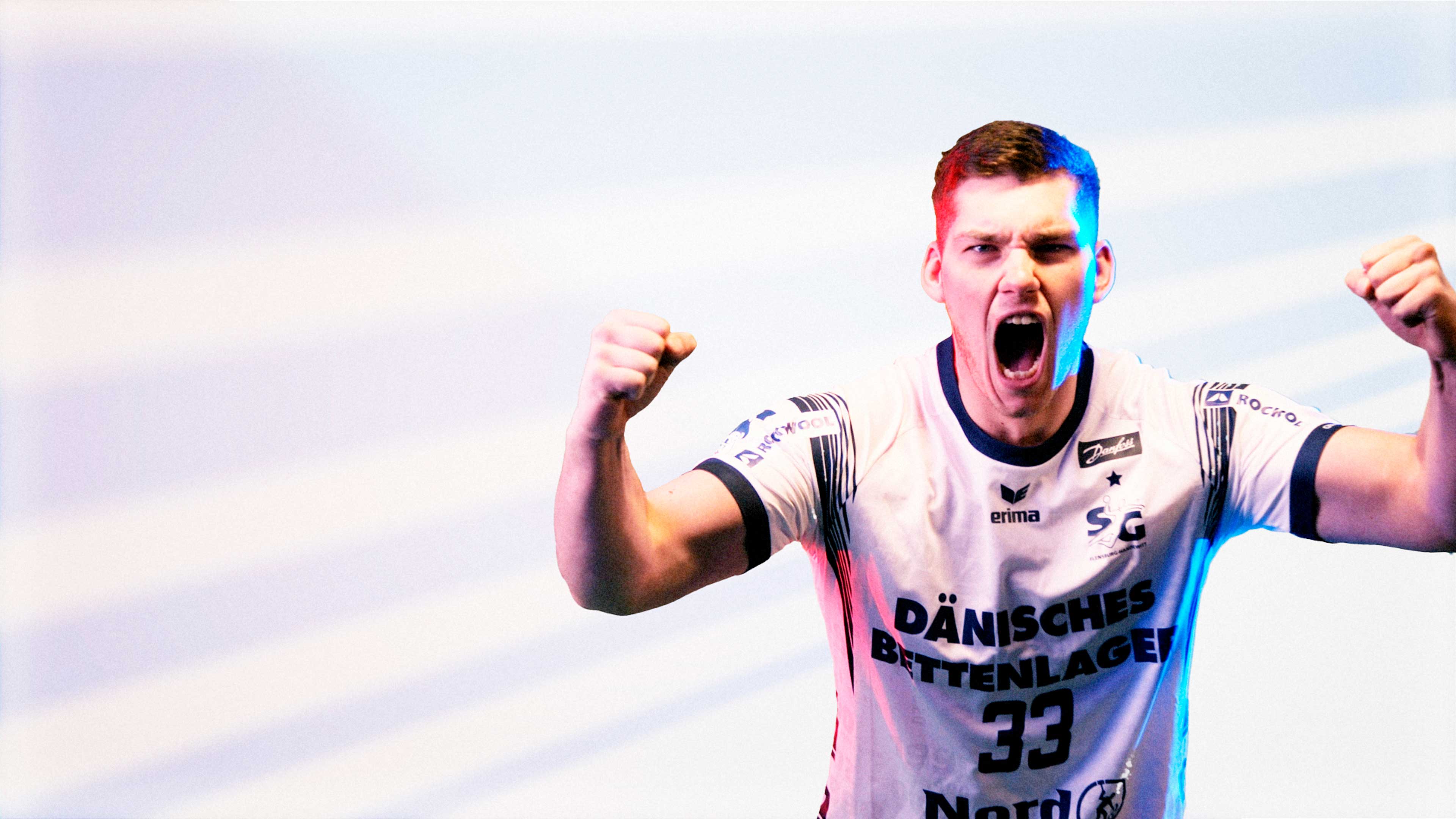 Ein SG Spieler im weißen Trikot jubelt in die Kamera