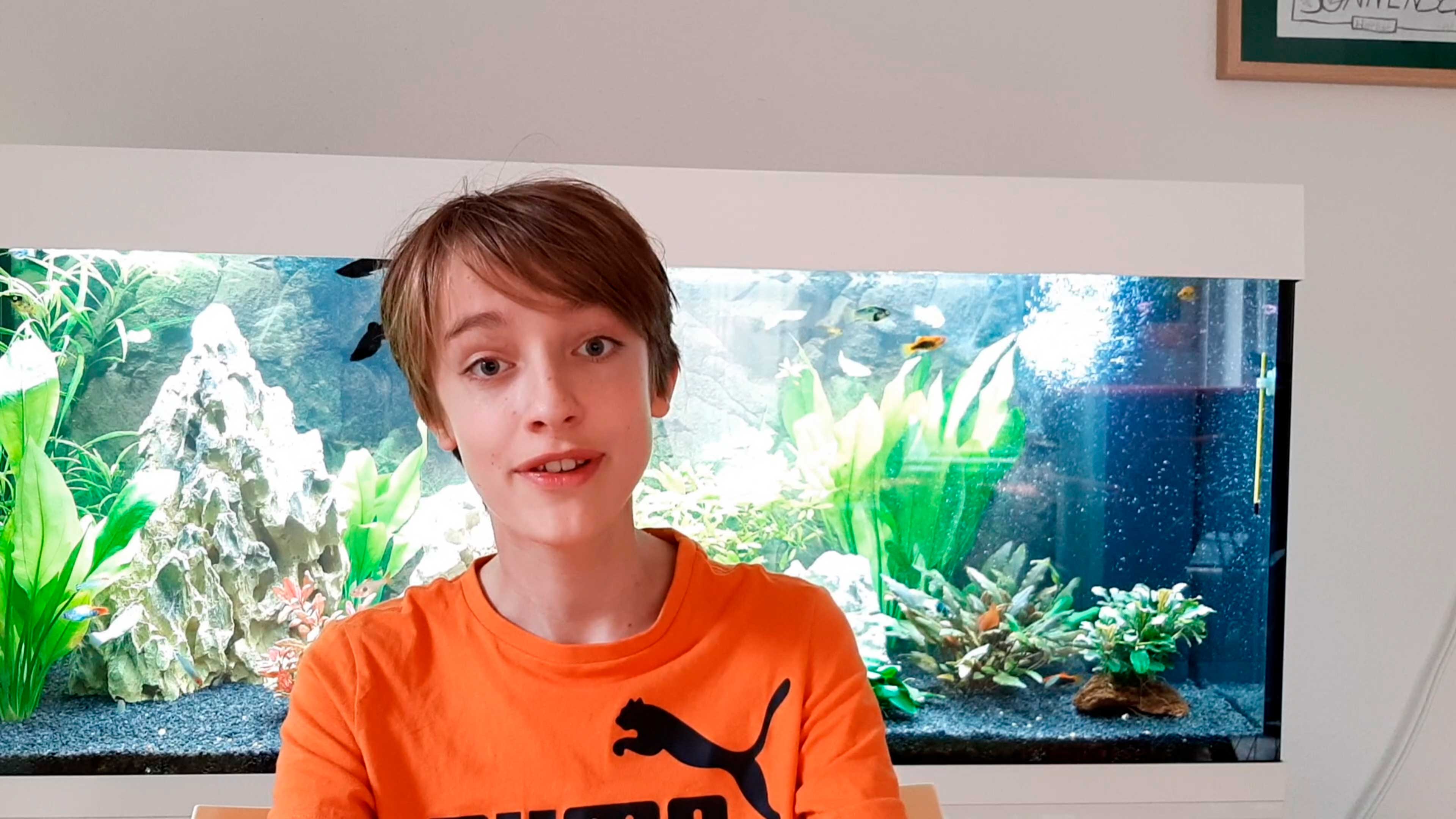 Ein Kind im orangenem Puma Shirt
